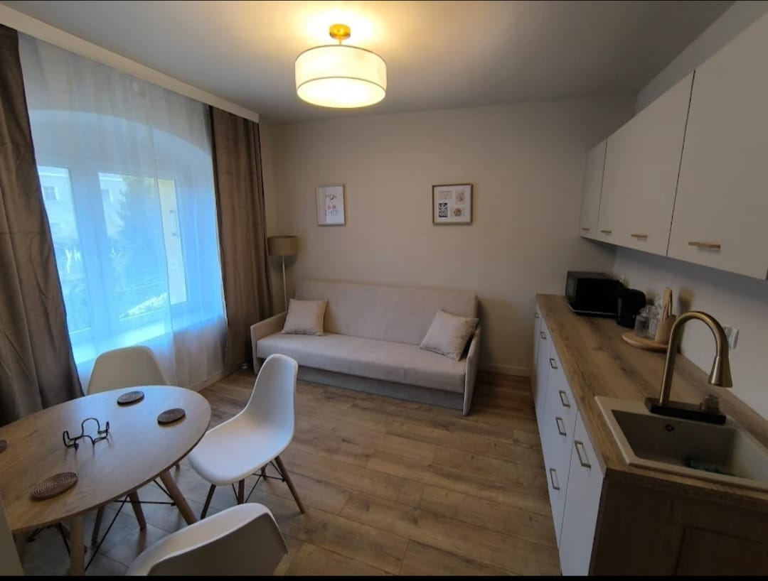 Jasny salon z aneksem kuchennym po wykończeniu pod klucz – realizacja ARK